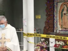 Fr. Vito Di Marzio, pastor of St. Elisabeth of Hungary parish, prays in front of the defaced mural
